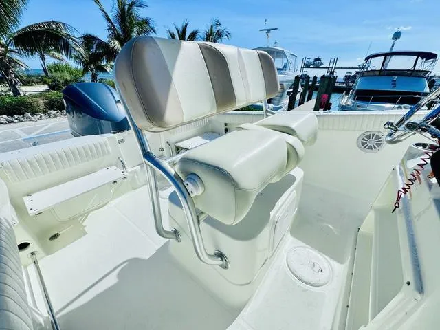 Slide: The Image of 2011 Hydra-Sports 2300CC boat interior with seating, docked near palm trees and other boats. - 10