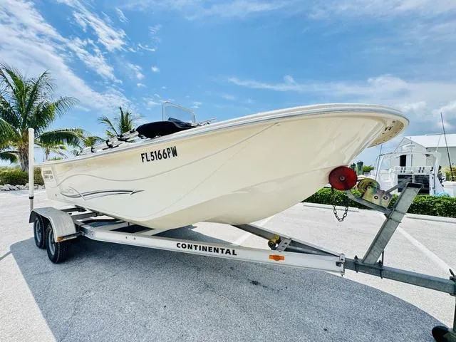 Slide: The Image of 2015 Carolina Skiff 198DLX boat on trailer, parked outdoors under blue sky. - 18