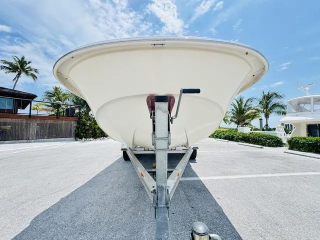 Slide: The Image of 2015 Carolina Skiff 198DLX boat on trailer, parked under a clear blue sky. - 19