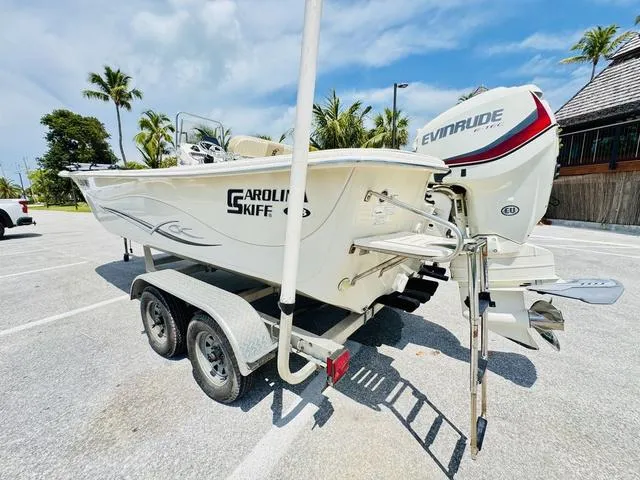 Slide: The Image of 2015 Carolina Skiff 198DLX boat on trailer with Evinrude engine, parked outdoors. - 3