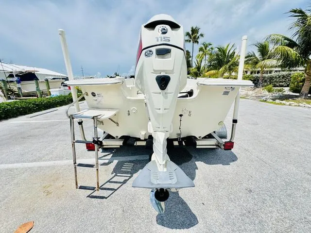 Slide: The Image of 2015 Carolina Skiff 198DLX boat with 115 HP outboard motor, parked on a sunny day. - 4