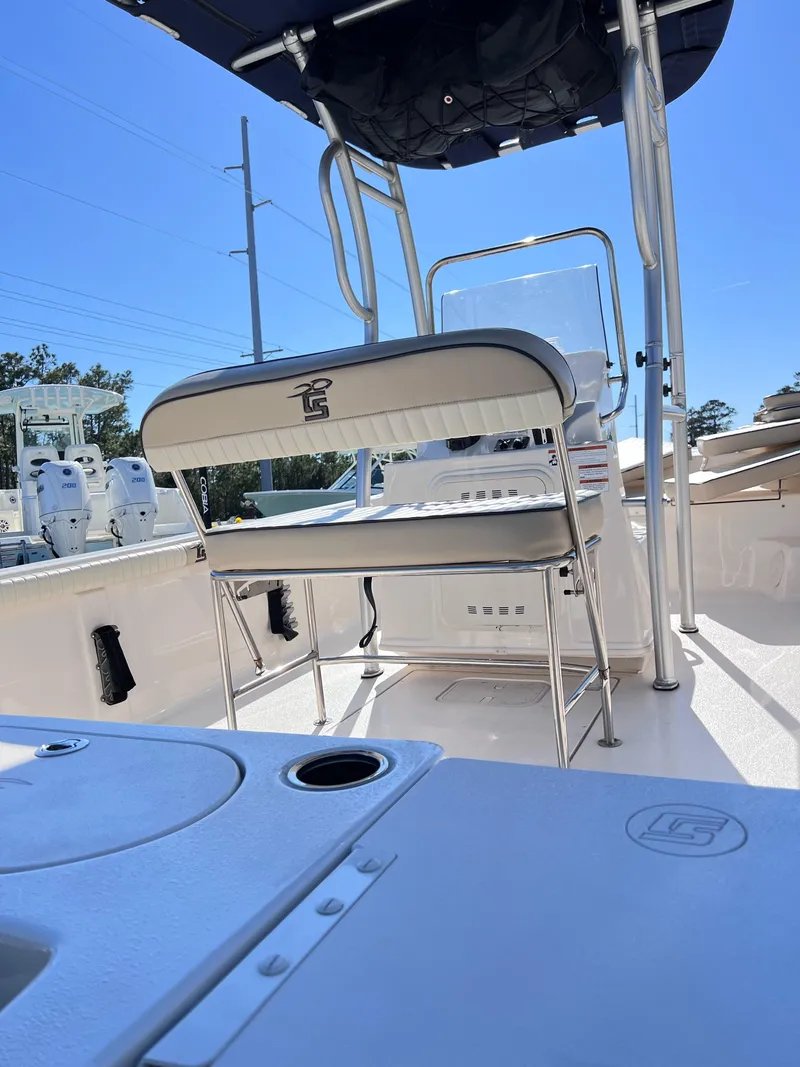 Slide: The Image of 2022 Carolina Skiff 19LS boat interior with seating and console under a clear blue sky. - 3