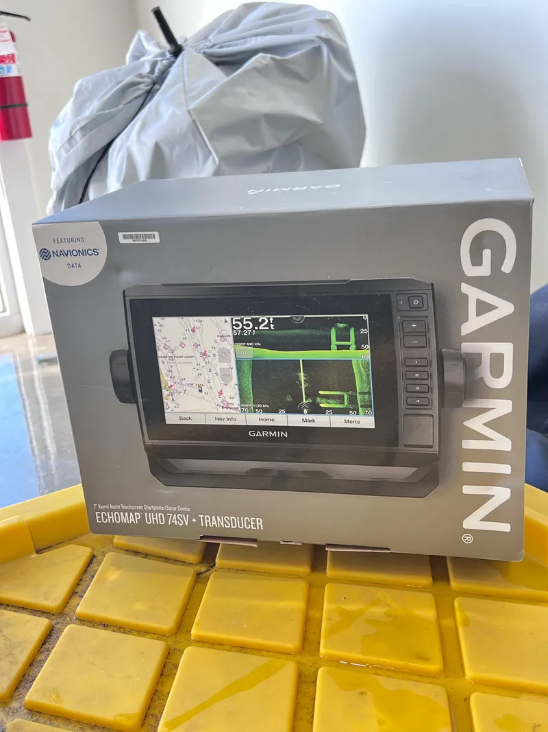 Slide: The Image of Box of Garmin ECHOMAP UHD 74SV with transducer on yellow surface. - 8