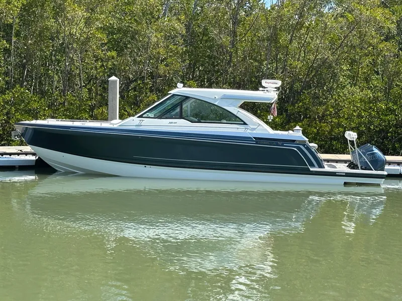 Slide: The Image of 2022 Formula 380 Super Sport Crossover boat docked on calm water. - 0