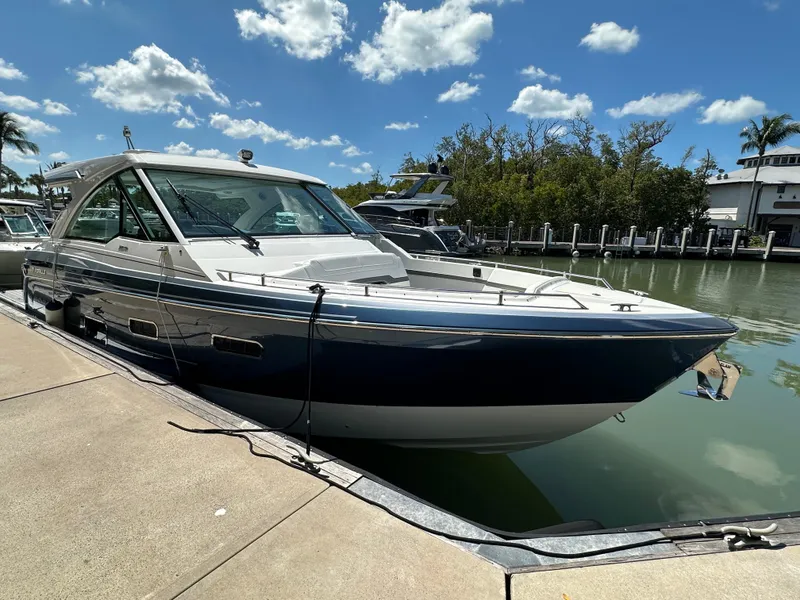 Slide: The Image of 2022 Formula 380 Super Sport Crossover boat docked by a sunny marina. - 1