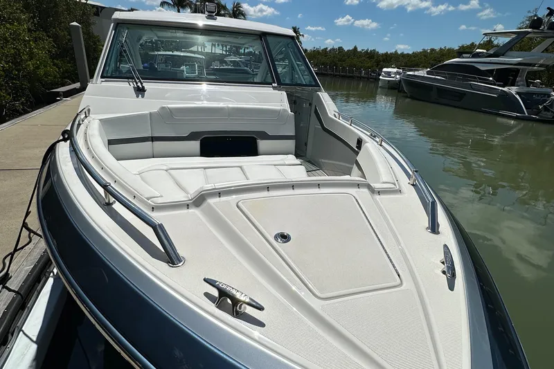 Slide: The Image of 2022 Formula 380 Super Sport Crossover boat docked on calm water under a clear sky. - 16