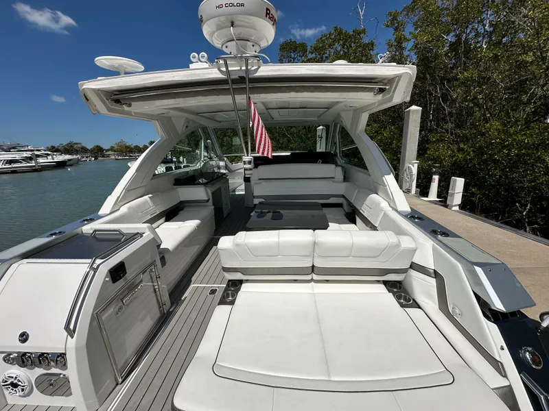 Slide: The Image of 2022 Formula 380 Super Sport Crossover boat docked, featuring spacious seating and modern design. - 19