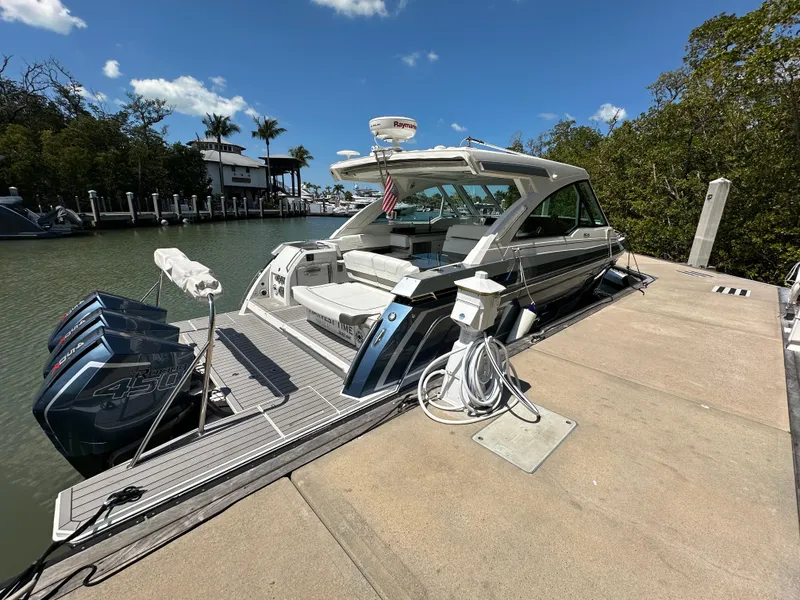 Slide: The Image of 2022 Formula 380 Super Sport Crossover docked by a scenic waterfront. - 5