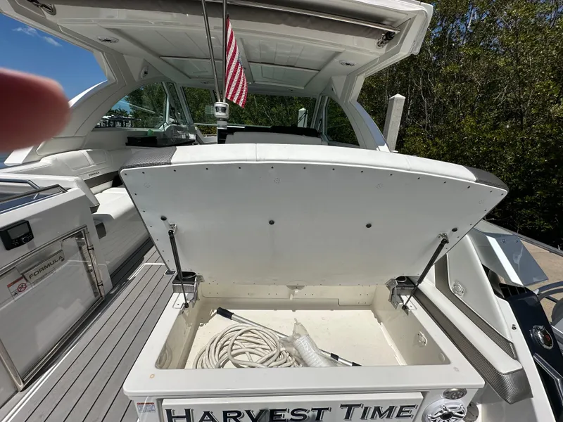 Slide: The Image of 2022 Formula 380 Super Sport Crossover boat with open storage compartment, "Harvest Time" nameplate. - 8