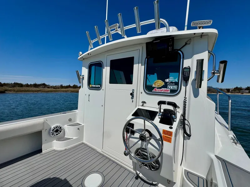 Slide: The Image of 2016 Parker 2820 XLD Sport Cabin boat on water, featuring steering wheel and cabin entrance. - 10