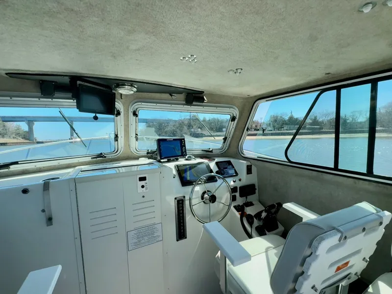 Slide: The Image of Interior of 2016 Parker 2820 XLD Sport Cabin boat with steering wheel and navigation equipment. - 6