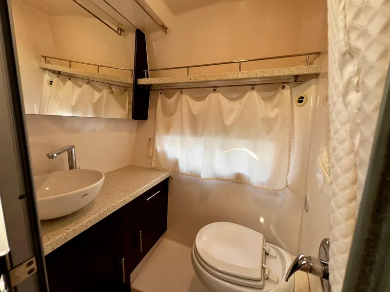 Slide: The Image of 2018 Regal 33 Express yacht kitchenette with sink, grill, and storage, docked at marina. - 17
