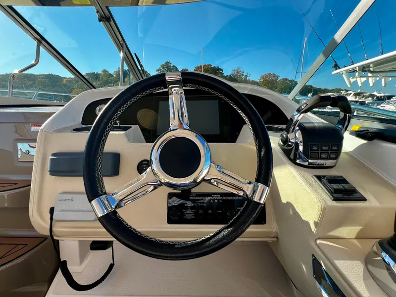 Slide: The Image of Steering wheel of a 2018 Regal 33 Express boat, showcasing modern dashboard controls. - 23