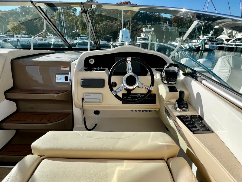 Slide: The Image of 2018 Regal 33 Express boat cockpit with steering wheel and control panel. - 28