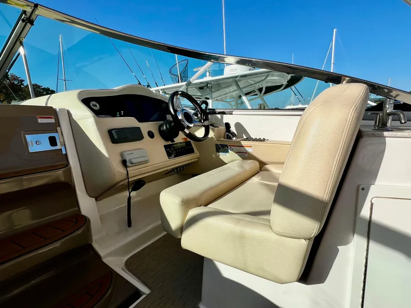 Slide: The Image of 2018 Regal 33 Express boat helm with beige seating and modern controls. - 30