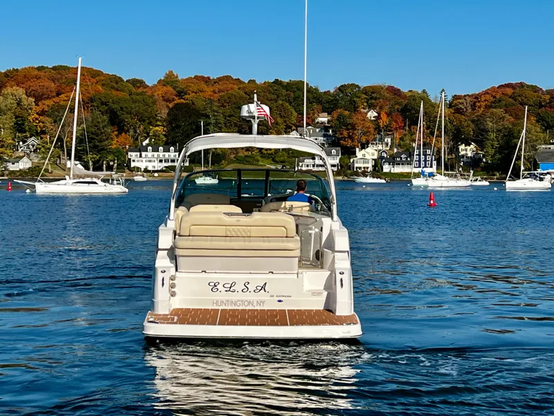 Slide: The Image of 2018 Regal 33 Express boat cruising on a scenic lake with autumn foliage. - 4