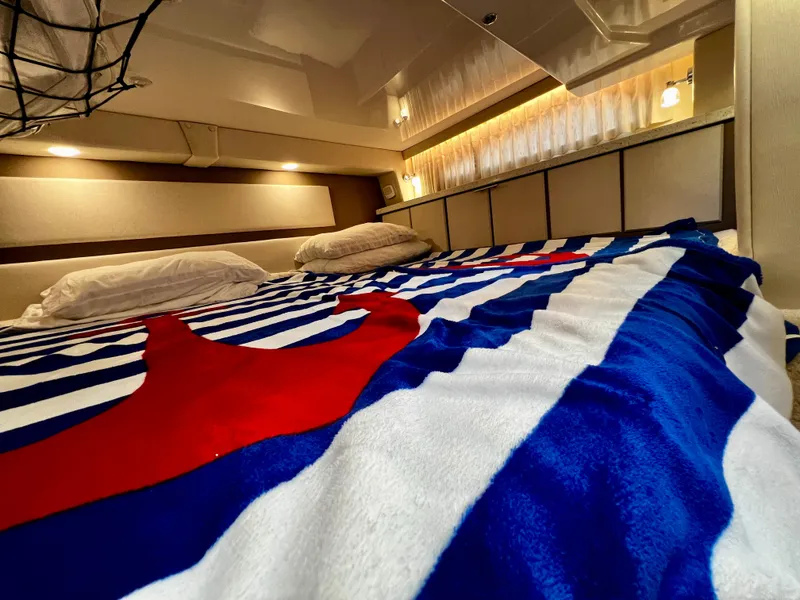 Slide: The Image of Luxurious cabin interior of 2018 Regal 33 Express with nautical-themed bedding. - 44