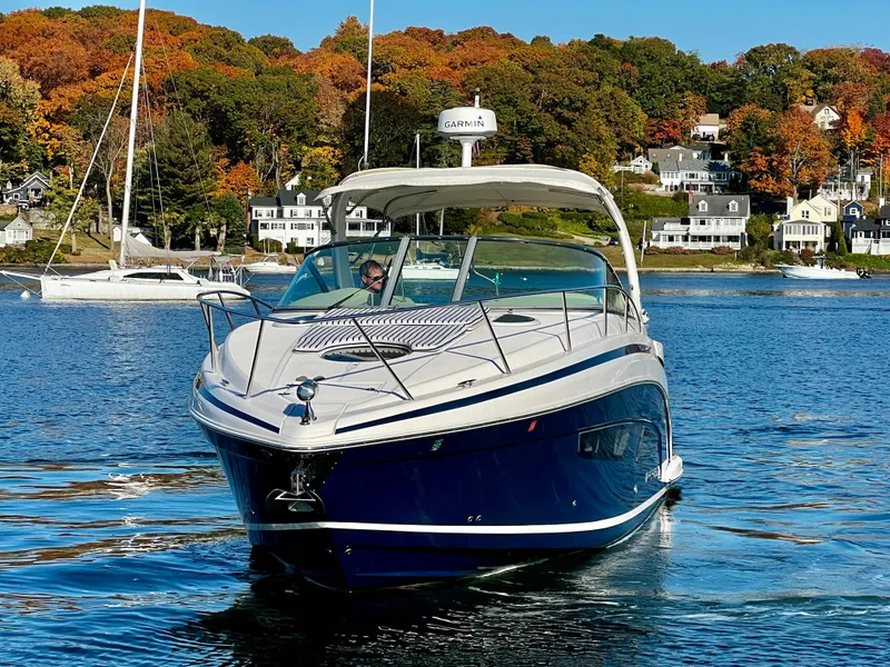 Slide: The Image of 2018 Regal 33 Express boat cruising on a scenic lake with autumn foliage. - 45