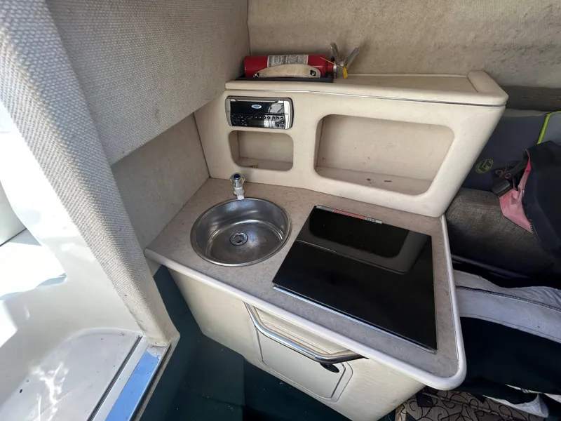 Slide: The Image of Compact kitchenette in a 2001 Sea Ray 245 Weekender boat with sink and stove. - 11