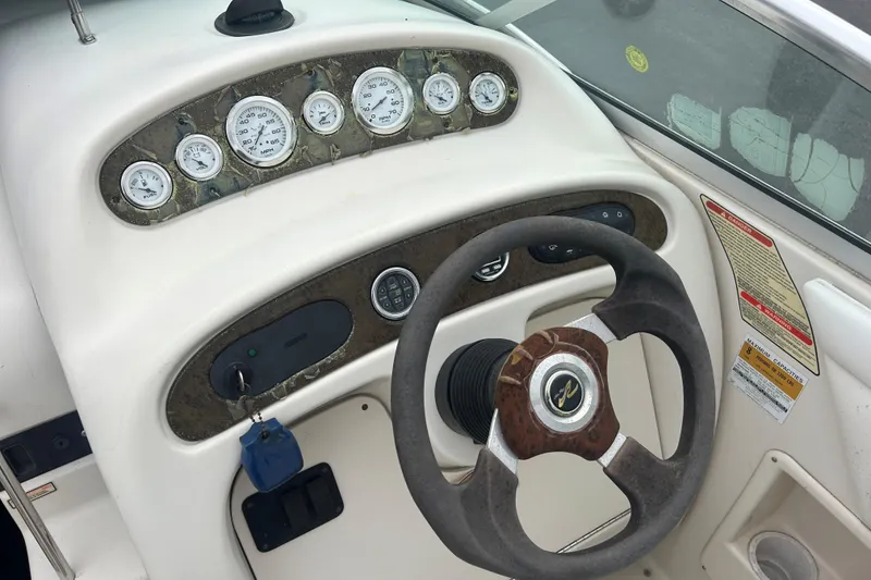 Slide: The Image of Steering console of a 2001 Sea Ray 245 Weekender boat with gauges and controls. - 12