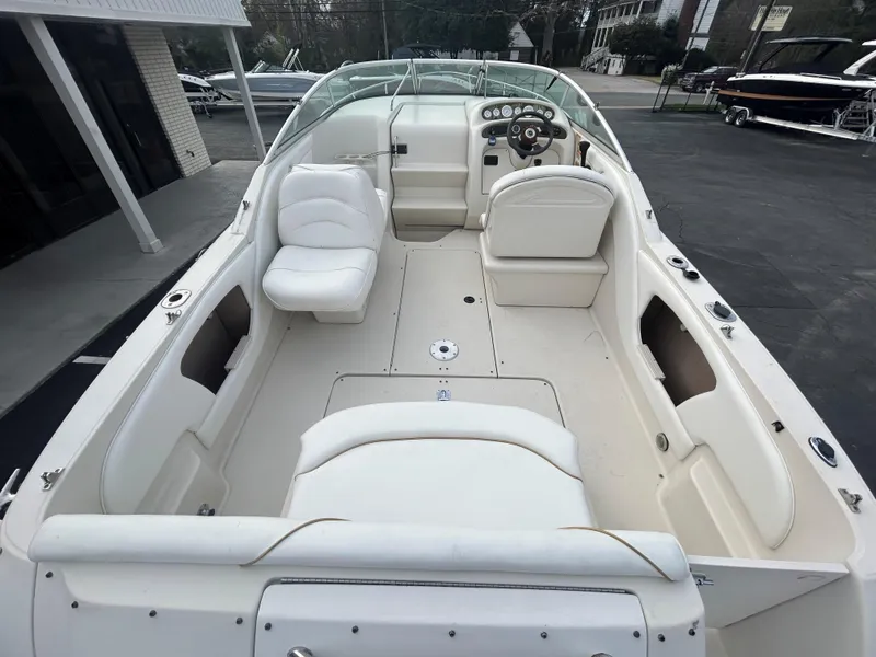 Slide: The Image of 2001 Sea Ray 245 Weekender boat interior with white seating and steering console. - 4