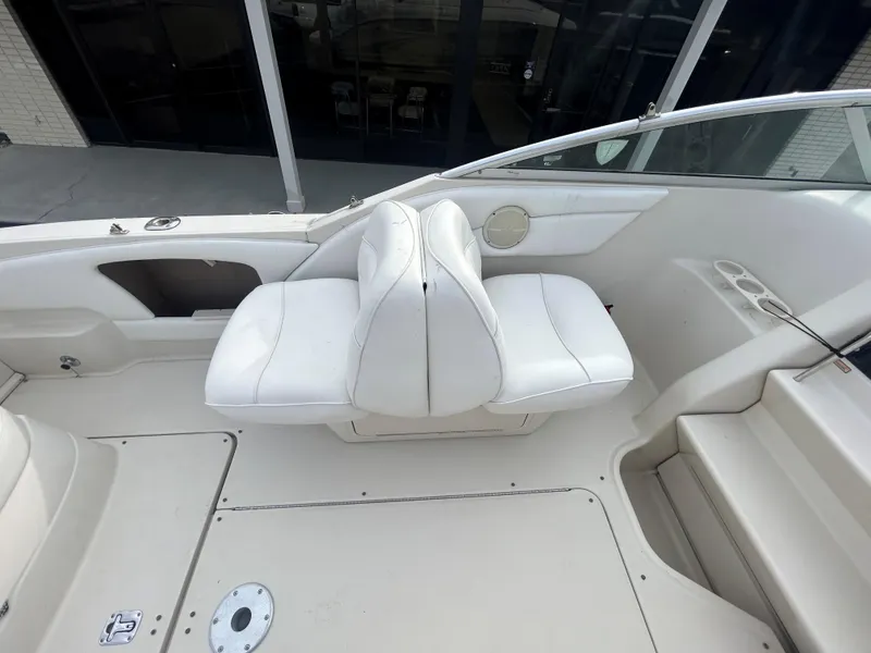 Slide: The Image of 2001 Sea Ray 245 Weekender boat interior with white seating and clean deck. - 6
