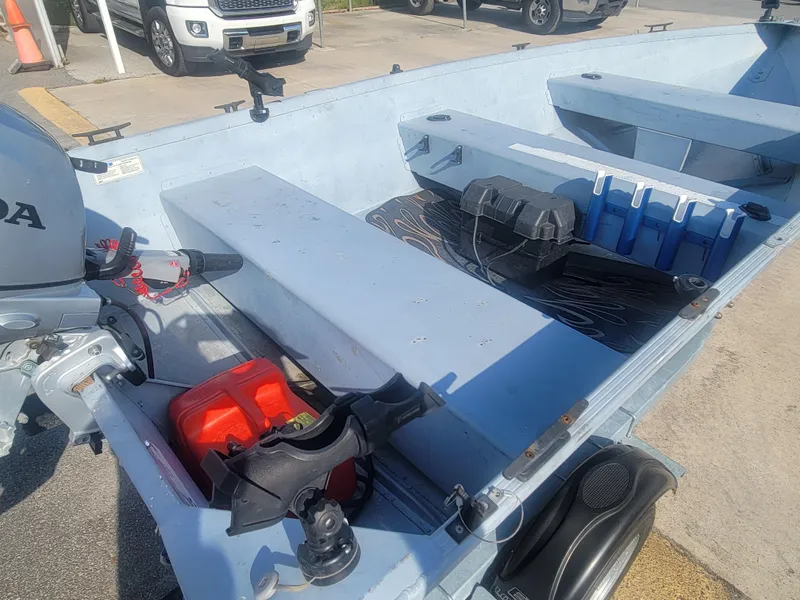 Slide: The Image of 2006 G3 Guide V12 boat interior with motor and equipment on a sunny day. - 10