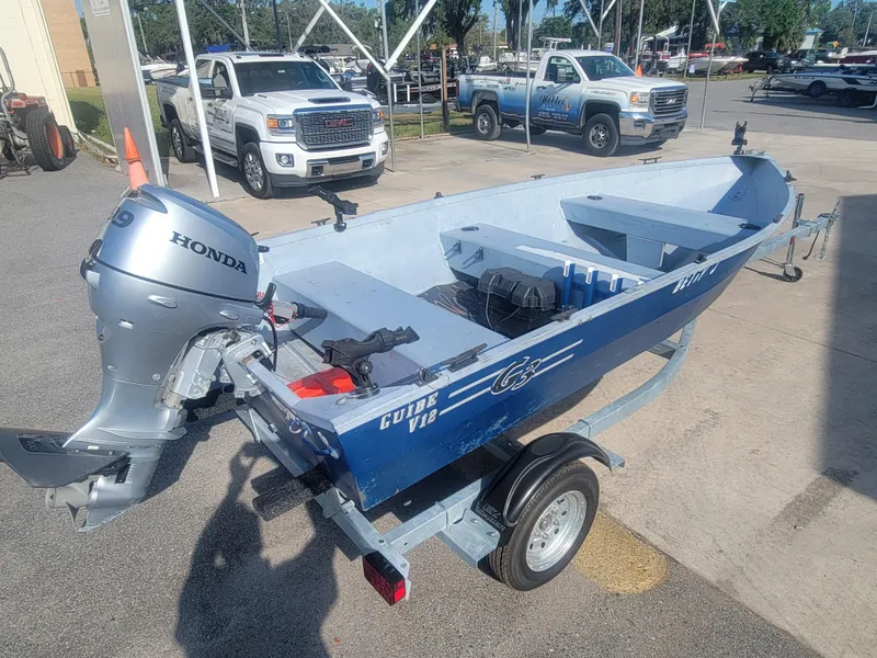 Slide: The Image of 2006 G3 Guide V12 boat with Honda motor on trailer in parking lot. - 3