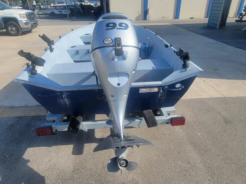 Slide: The Image of 2006 G3 Guide V12 boat with outboard motor on trailer, parked outdoors. - 4