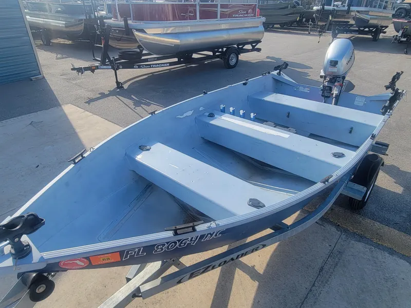 Slide: The Image of 2006 G3 Guide V12 boat on trailer with outboard motor in a parking lot. - 5