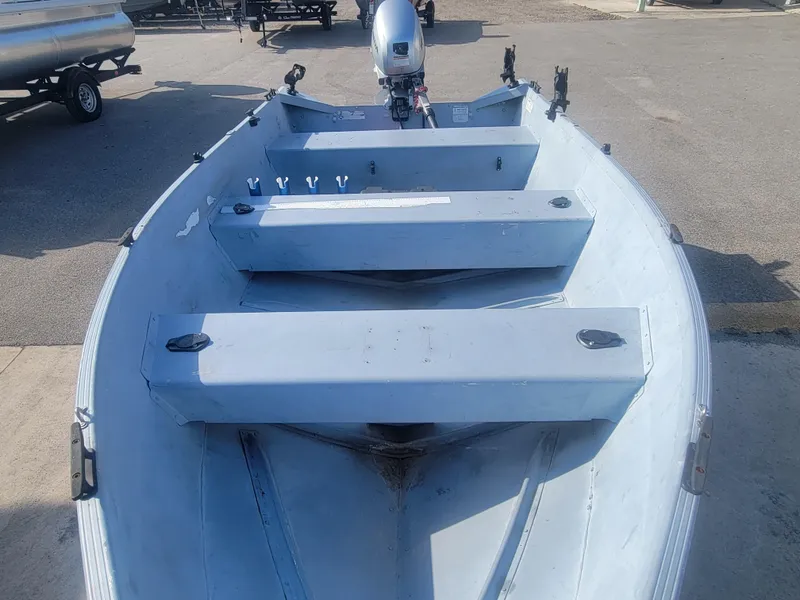 Slide: The Image of 2006 G3 Guide V12 boat with motor, parked on pavement. - 6