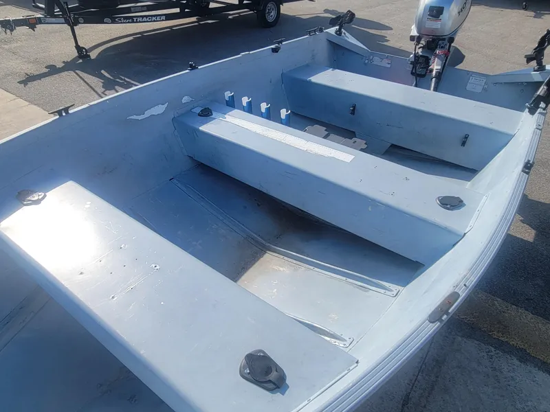 Slide: The Image of 2006 G3 Guide V12 boat interior with seating and motor, parked on a trailer. - 7