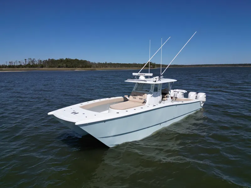 Slide: The Image of 2024 Freeman 37 VH boat on open water, clear sky, dual outboard engines. - 1