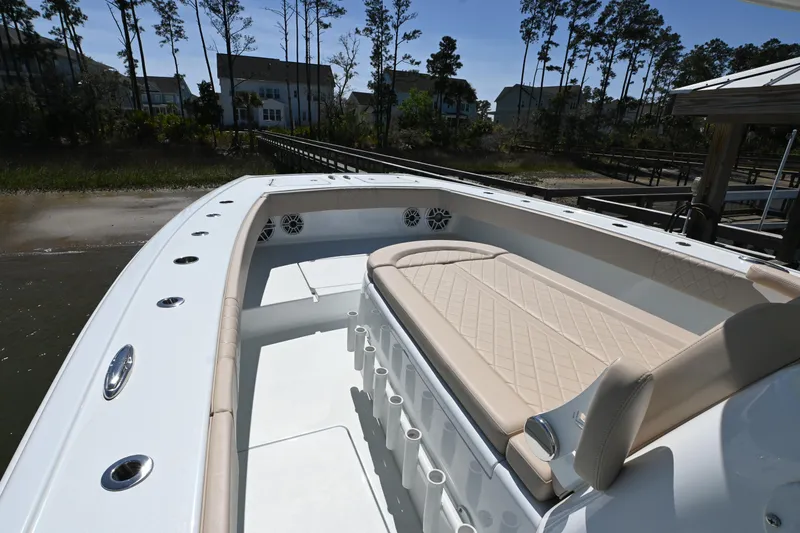 Slide: The Image of 2024 Freeman 37 VH boat interior with beige seating, docked near trees and houses. - 10