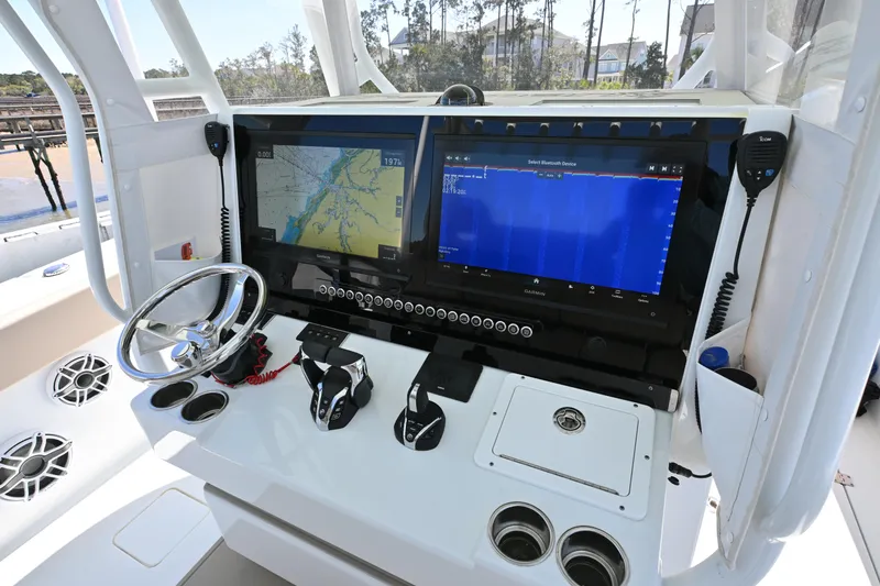 Slide: The Image of 2024 Freeman 37 VH boat dashboard with dual navigation screens and steering wheel. - 13