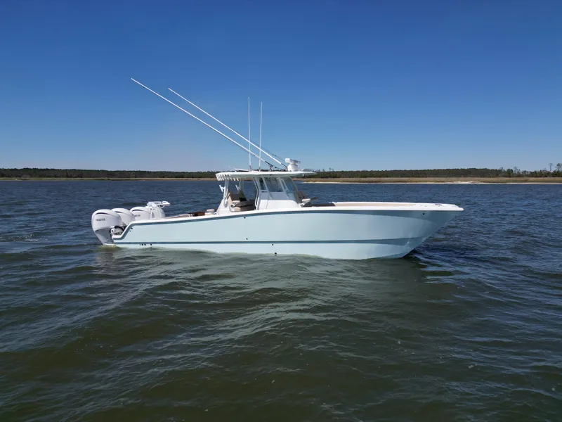 Slide: The Image of 2024 Freeman 37 VH boat on calm water under clear blue sky. - 2