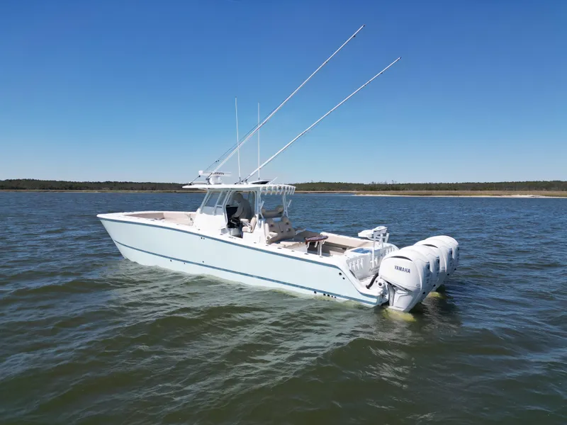 Slide: The Image of 2024 Freeman 37 VH boat on water with triple outboard engines, clear sky background. - 3