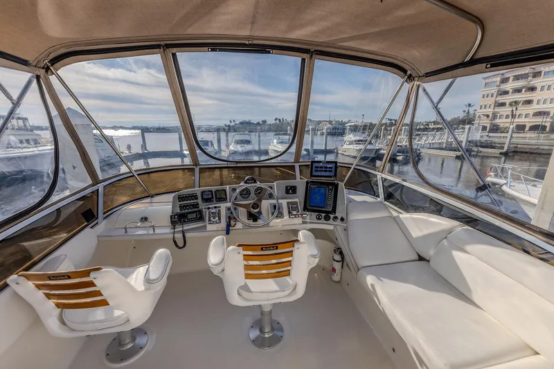 Slide: The Image of 2003 Regal Commodore 3880 yacht cockpit with marina view, featuring dual captain chairs and navigation equipment. - 10