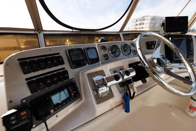 Slide: The Image of 2003 Regal Commodore 3880 helm with steering wheel, gauges, and navigation equipment. - 13