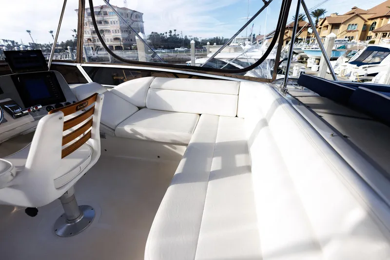 Slide: The Image of 2003 Regal Commodore 3880 yacht interior with white seating and marina view. - 18