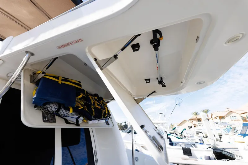 Slide: The Image of Open storage compartments on a 2003 Regal Commodore 3880 boat, showing life jackets and equipment. - 38