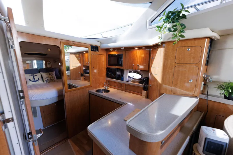 Slide: The Image of Interior of 2003 Regal Commodore 3880 yacht with modern kitchen and cozy bedroom. - 48