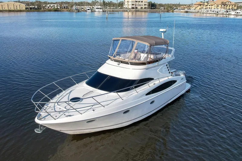 Slide: The Image of 2003 Regal Commodore 3880 yacht on calm water, featuring sleek design and spacious deck. - 5