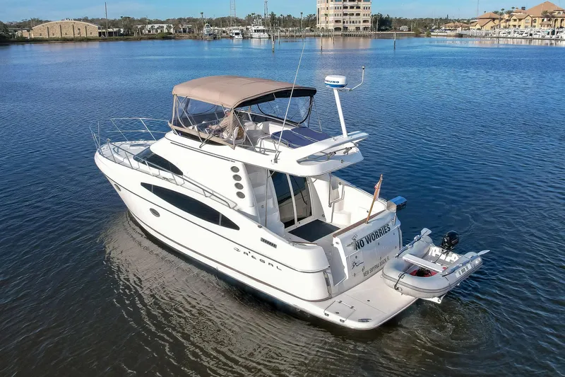 Slide: The Image of 2003 Regal Commodore 3880 yacht on calm water with cityscape background. - 8