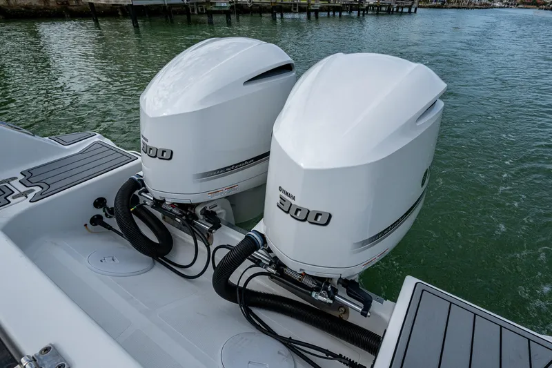 Slide: The Image of Twin outboard engines on a 2020 Wellcraft 302 Fisherman boat, docked on calm water. - 11