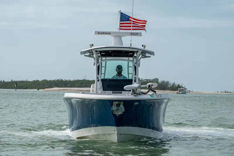 Slide: The Image of 2020 Wellcraft 302 Fisherman boat on water, American flag, Garmin equipment visible. - 2
