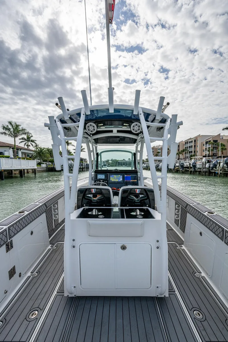 Slide: The Image of 2020 Wellcraft 302 Fisherman boat with dual consoles, docked in a scenic marina. - 22