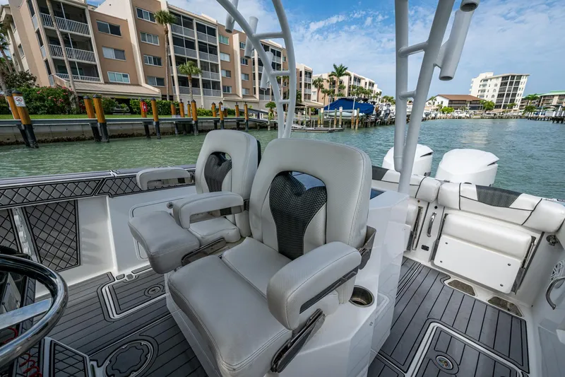 Slide: The Image of 2020 Wellcraft 302 Fisherman boat interior with luxury seating, docked near waterfront buildings. - 26