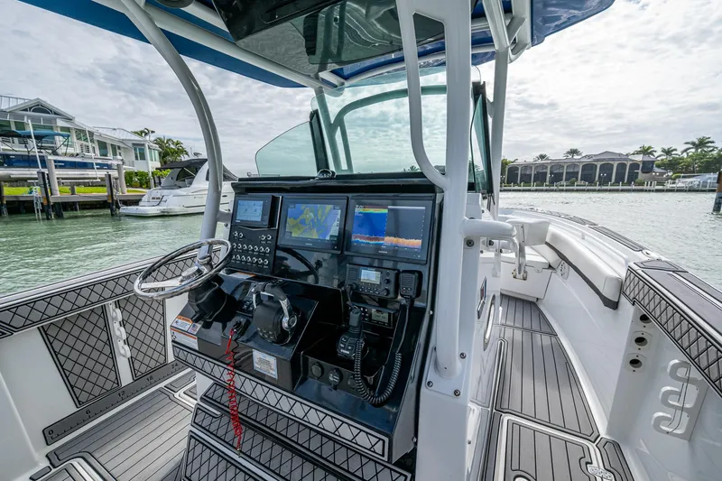 Slide: The Image of 2020 Wellcraft 302 Fisherman boat cockpit with advanced navigation systems and waterfront view. - 27