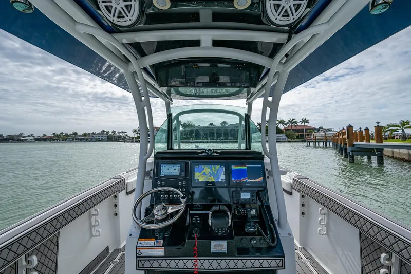 Slide: The Image of 2020 Wellcraft 302 Fisherman boat dashboard with navigation screens and steering wheel. - 28